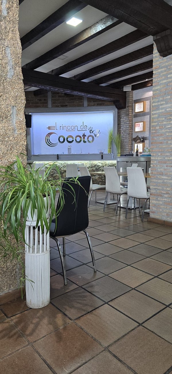 Sala interior con vigas de madera y muro de ladrillo